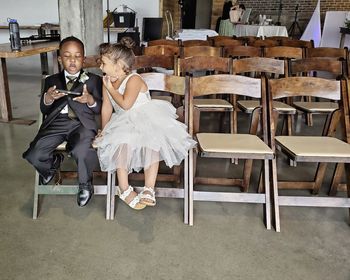 Rear view of two people sitting on chair