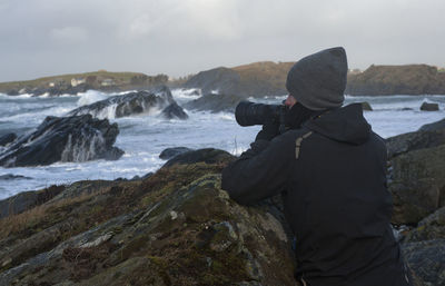 Rear view of man photographing sea