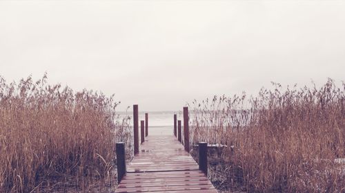 Wooden pier amidst sea against clear sky