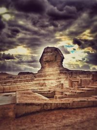 View of rock formation against cloudy sky