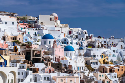 Buildings in town against blue sky