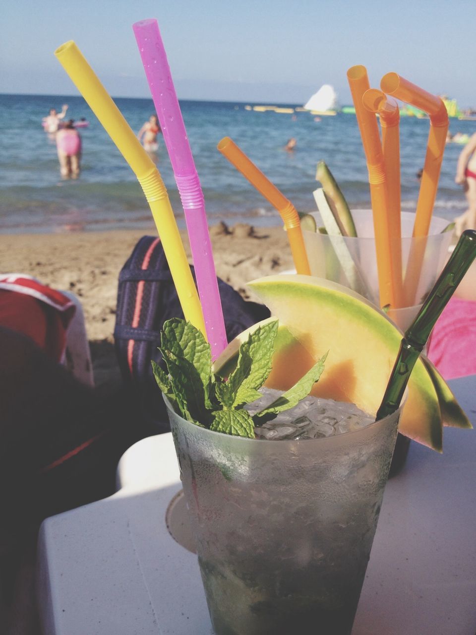 water, horizon over water, sea, flower, freshness, beauty in nature, plant, beach, potted plant, nature, table, growth, day, close-up, fragility, focus on foreground, tranquility, outdoors, sunlight, leaf