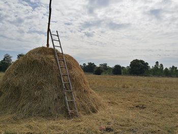 Hay bales on field against sky