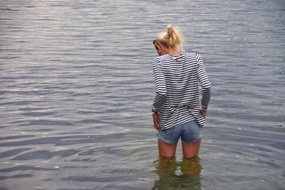 Rear view of woman standing in lake