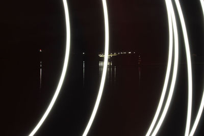 Low angle view of light trails against sky at night