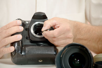 Midsection of man cleaning dslr camera