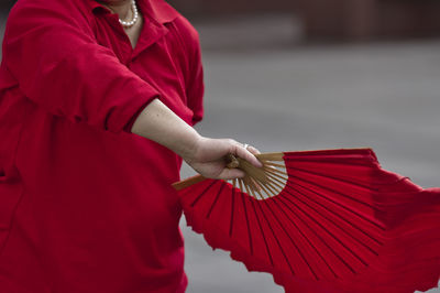 Midsection of woman holding red umbrella