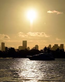 River by city against sky during sunset