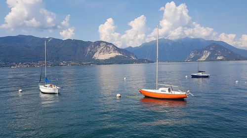 Sailboats sailing in lake against sky