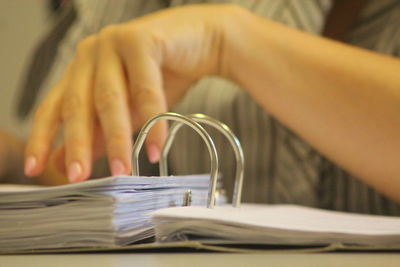 Close-up of person holding paper on table 