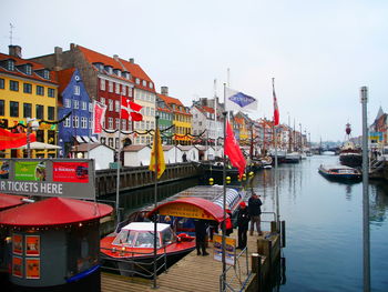 Boats moored at harbor against clear sky