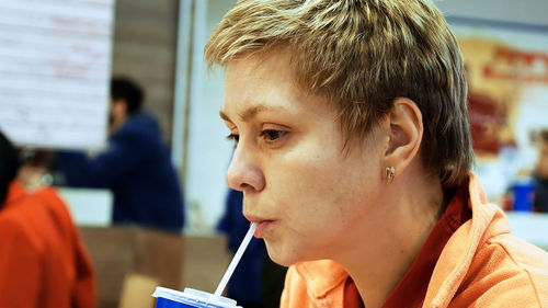 Close-up of woman drinking at restaurant