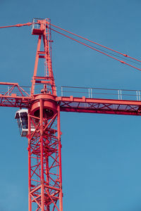 Low angle view of crane against clear blue sky