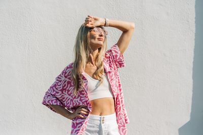 Young woman standing against wall