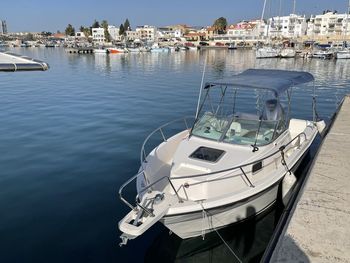 Sailboats moored at harbor in city