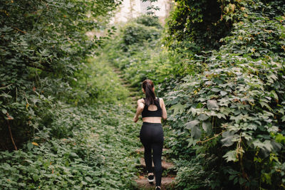 Rear view of woman running up stairs in park