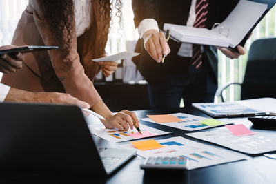 Midsection of business colleagues working on table