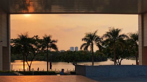 Swimming pool by sea against sky during sunset