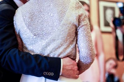 Close-up of groom embracing bride