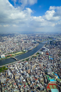 High angle view of city buildings against cloudy sky