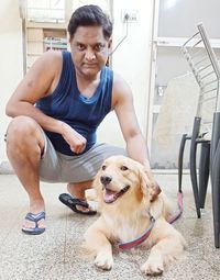 Portrait of young man with dog sitting outdoors