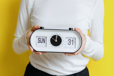 The girl holds a watch with the time, day and date