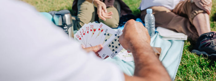 Unrecognizable adult family playing cards during an excursion