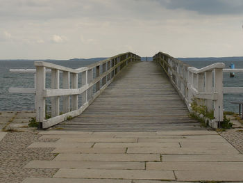 Footpath leading to beach against sky