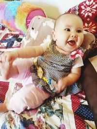 Portrait of cute baby girl lying on bed