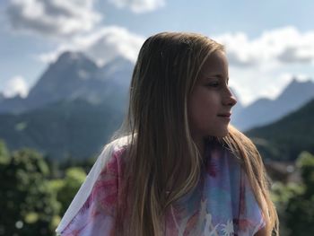 Girl looking away against mountains