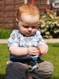 Cute baby boy sitting outdoors