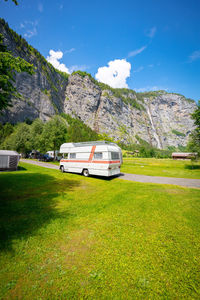 A white historic van with orange red stripes in lauterbrunnen valley on a campsite.