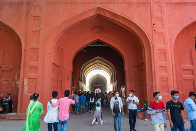 Rear view of people walking in tunnel