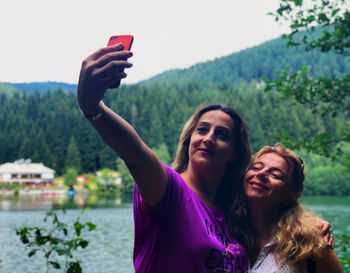 Portrait of smiling young woman using mobile phone