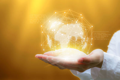 Digital composite image of hands holding globe