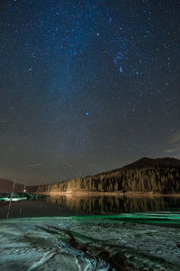 Scenic view of lake against star field at night