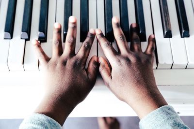 Cropped hand of child playing piano