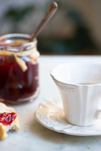 Close-up of coffee and strawberry jam with baguette on table