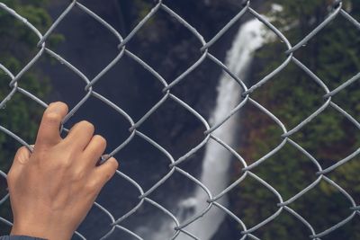 Close-up of hand on chainlink fence