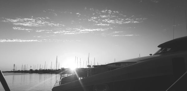 Sailboats moored on sea against sky