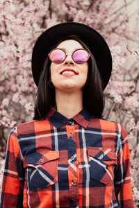 Beautiful woman wearing sunglasses and hat while standing outdoors