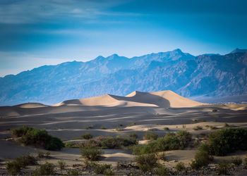 Scenic view of mountains against blue sky