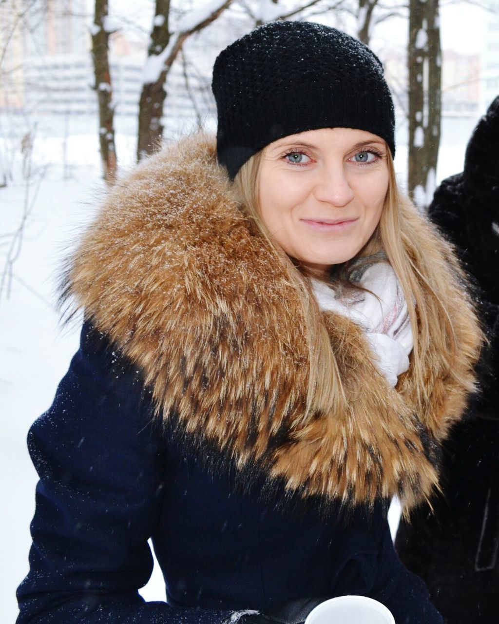 portrait, looking at camera, winter, person, warm clothing, young adult, lifestyles, cold temperature, front view, headshot, snow, leisure activity, smiling, casual clothing, waist up, focus on foreground, young women, sitting