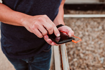 Midsection of man using mobile phone