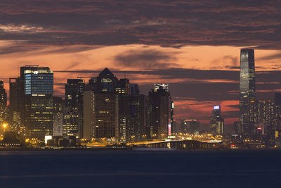 Illuminated buildings in city against sky at night