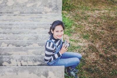 Portrait of smiling young woman using mobile phone