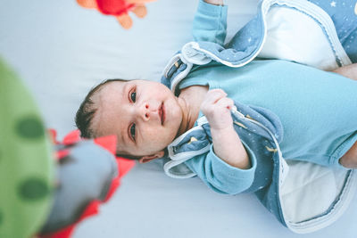 High angle view of baby lying on crib