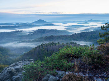 Summer morning with clear blue sky and rising sun over hills hilly landscape view from above. 