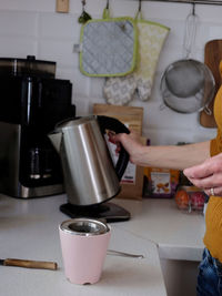 Midsection of woman having coffee at home