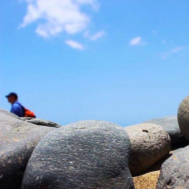 blue, sky, rock - object, bird, day, animals in the wild, nature, rear view, outdoors, animal themes, cloud - sky, full length, wildlife, stone - object, rock, sunlight, built structure, men